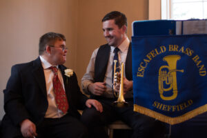 Picture of Jon beside Alistair holding a cornet, smiling at each other.